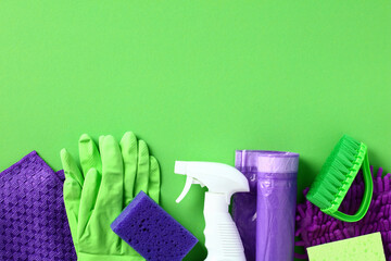 Set of house cleaning products on green background. Flat lay, top view