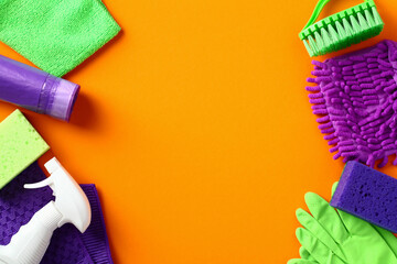 Cleaning service banner design. Frame made of cleaning items and supplies on orange background....