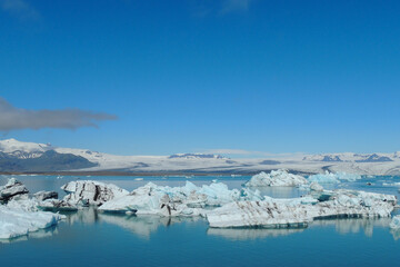 Fototapeta na wymiar Bright clear blue iceberg floating in the Jokulsarlon lake blue cold water in Iceland 59