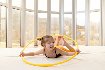 Little blonde girl with piggy tails playing with hula hoop