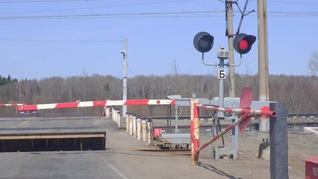 Railway crossing with a barrier. Flashing Red traffic light at a railway crossing.