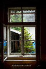 A view of rain from a wooden window of an old cottage