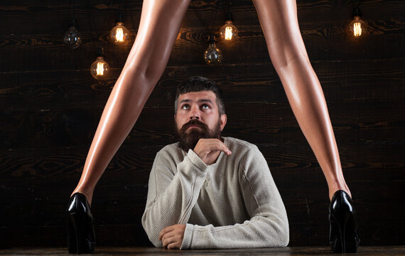 Couple playing with sexy legs. Handsome man holding womans leg in elegant shoes.