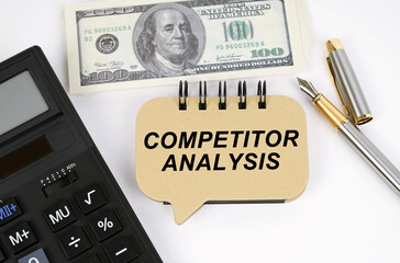 On a white surface, a calculator, dollars, a pen and a sign with the inscription - COMPETITOR ANALYSIS