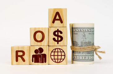 On a white surface, dollars and cubes with images and the inscription - ROA