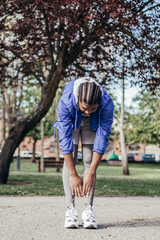 Fototapeta premium african americanman stretching calves in park
