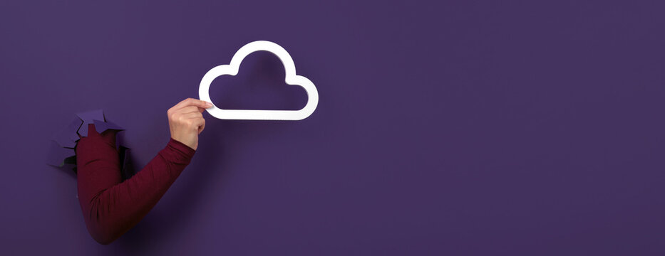 hand holding cloud over purple background, cloud storage, panoramic image