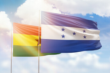 Sunny blue sky and flags of honduras and ghana