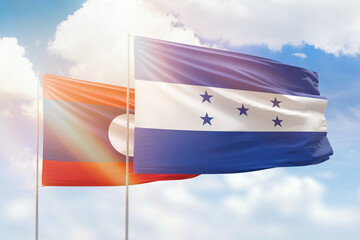 Sunny blue sky and flags of honduras and laos