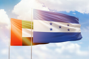 Sunny blue sky and flags of honduras and uae