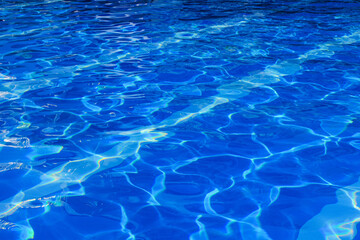 Fototapeta na wymiar Pattern in swimming pool background. Beautiful Blue pool reflecting the sun ripples. Textured water background.