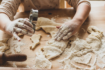 girl cook at home cookies. in a kitchen, a child stirs flour, knead the dough on the table by hand