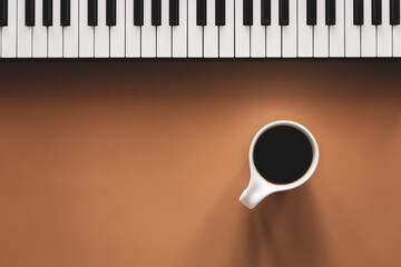 Flat lay, piano keys and coffee cup, conceptual minimalism.