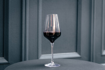 A glass of red wine on a blue background isolated.