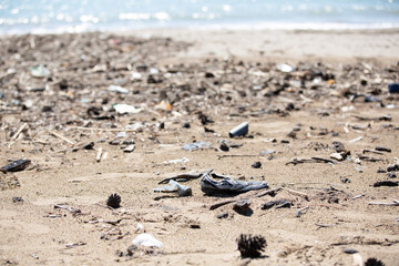 Fototapeta premium Environmental pollution, beached garbage and old shoes