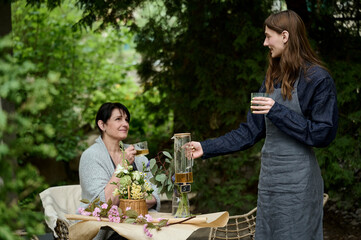 two florists mom and daughter drinking tea in the garden