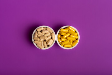 Tablet vitamins in jars on a purple violet background from above. 