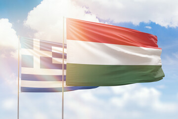 Sunny blue sky and flags of hungary and greece