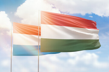 Sunny blue sky and flags of hungary and luxembourg