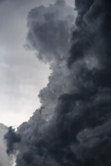 Dark, gloomy, stormy, rainy sky with rays of light. Terrible hurricane clouds. Background image for design