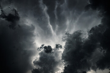 Dark, gloomy, stormy, rainy sky with rays of light. Terrible hurricane clouds. Background image for...