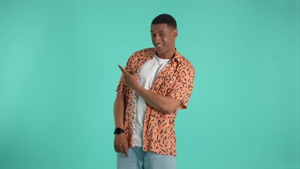 Positive dark-skinned man pointing fingers to different sides like pistols inviting viewers to pay attention to offers, go shopping. Joyful promoter symbolically offering buyers to make choice