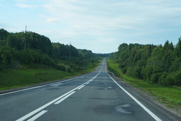 Empty highway through the forest. Beautiful summer landscape background. Travel