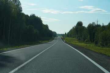 Empty highway through the forest. Beautiful summer landscape background. Travel