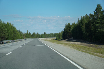 Empty highway through the forest. Beautiful summer landscape background. Travel