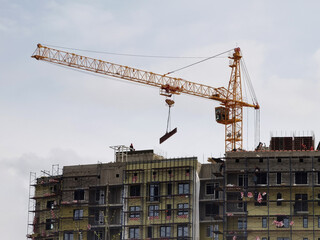 Crane and unfinished house. Building construction. A Crane is pulling a detail of a house.