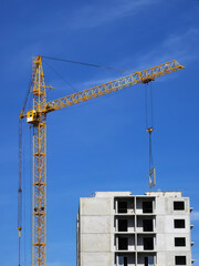 Crane and unfinished house. Building construction. A Crane is pulling a detail of a house.