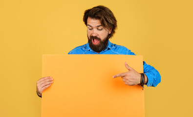 Bearded man with advertising board pointing finger at copy space. Shopping. Season sale. Discount.