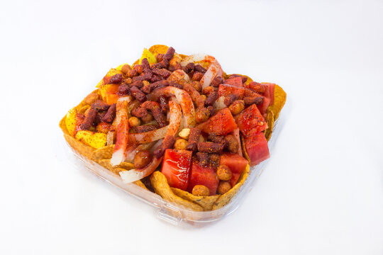 Plato de fruta con tostitos y cueritos para botana