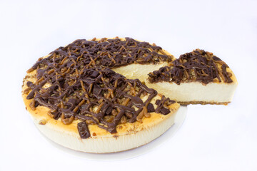 Pai de queso con cajeta al cual se le extrae una rebanada