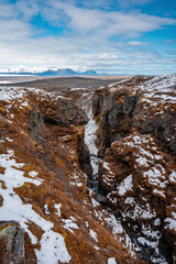 High angle view of snow covered mountains. Scenic view of icecap rock formations in volcanic valley against sky. Beautiful scenery of Icelandic winter landscape.