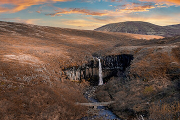 Aerial view of Svartifoss waterfall surrounded by basalt columns. Beautiful scenery of falling...
