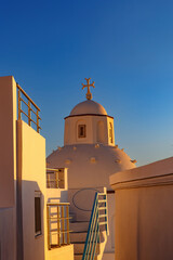 White church on Santorini island during orange sunset.