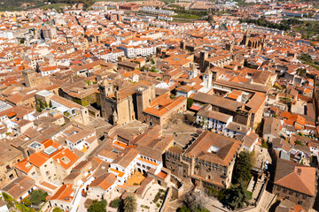 Scenic aerial view of ancient quarter of Spanish city of Caceres overlooking brownish tiled roofs...