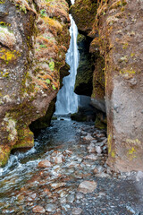 Scenic cascades of Gljufrafoss flowing through stream. Hidden beautiful waterfall in valley. Close-up idyllic view of famous tourist attraction in mountain.