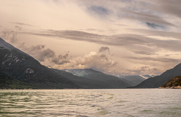 Skagway, Alaska, USA - July 20, 2011: Taiya Inlet above Chilkoot Inlet. Brown cloudscape over mountains at end of long shot over fjord water. Mountain flanks on sides