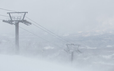 Ski lift pylons in mist stormy snow winter landscape