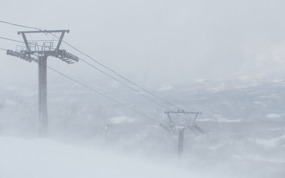 Ski lift pylons in mist stormy snow winter landscape
