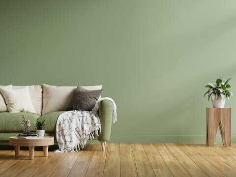 Interior wall mockup in dark tones with green sofa on green wall background.