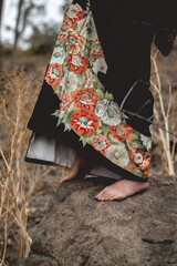 Closeup of beautiful old traditional black kimono with flowers and sexy japanese woman feet over a...