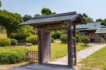 日本庭園の入口に立つ古い木造の門