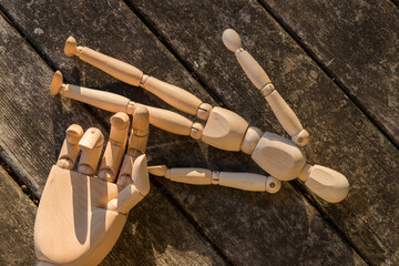 古いテーブルの上にある木製のロボットの片手とマネキン人形の姿