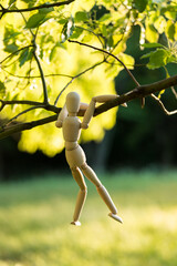 夏の公園で擬人化で撮影した木の枝に登る面白いマネキン人形の姿