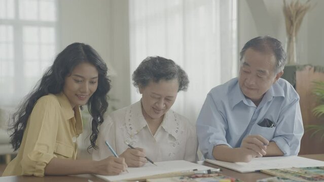 Artist concept of 4k Resolution. Asian families drawing together in the living room. Artist is creating work. Leisure activities and hobbies.