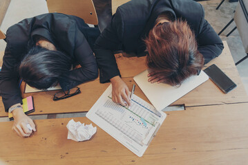 Top view two Asian businesswoman overworked at office desk feel stressful anxiety with serious problems. Two Woman exhaustion depress, mental burnout feeling tired frustrate at company office concept
