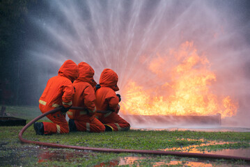 Firefighter Rescue team training in fire fighting extinguisher. Firefighter teamwork fighting with...